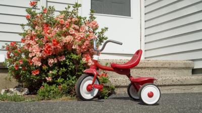 Red tricycle in front of house