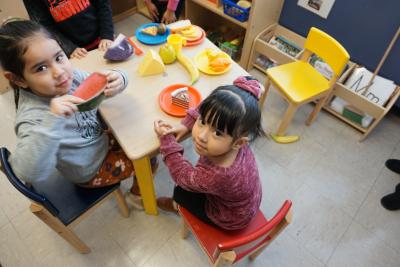 Children playing with fake food at a table