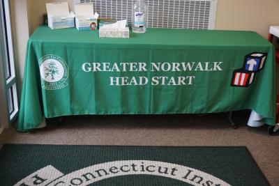 Table with Greater Norwalk Head Start on tablecloth